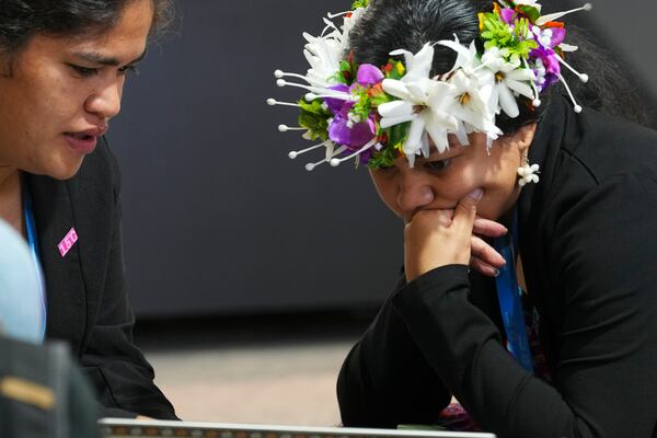 Demi Afasene, of Tuvalu, right, looks through a draft of a proposed deal for curbing climate change at the COP29 U.N. Climate Summit, Friday, Nov. 22, 2024, in Baku, Azerbaijan. (AP Photo/Peter Dejong)