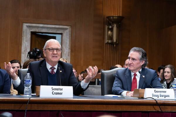 Sen. Kevin Cramer, R-N.D., left speaks as former Gov. Doug Burgum, President-elect Donald Trump's choice to lead the the Interior Department as Secretary of the Interior looks on as he wait to testify before the Senate Energy and Natural Resources Committee on Capitol Hill in Washington, Thursday, Jan. 16, 2025. (AP Photo/Jose Luis Magana)