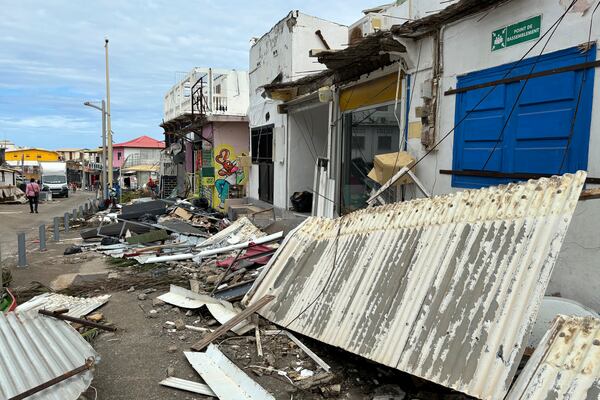 Debris are seen in a street of Mamoudzou, in the French Indian Ocean territory of Mayotte, Monday, Dec.16, 2024 and France uses ships and military aircraft to rush rescue workers and supplies after the island group was battered by its worst cyclone in nearly a century. (AP Photo/Rainat Aliloiffa)