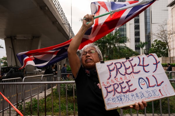 FILE- A pro-democracy activist known as "Grandma Wong" protests outside the West Kowloon courts in a cordoned off area set up by police as closing arguments open in Hong Kong's largest national security trial of 47 pro-democracy figures in Hong Kong, Nov. 29, 2023. (AP Photo/Louise Delmotte, File)