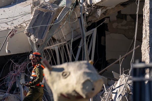 An officer from the home front command military unit examines the damaged after a large piece of shrapnel from Houthi missile collapsed a school building in Ramat Gan, a suburb of Tel Aviv, Israel, Thursday, Dec. 19, 2024. (AP Photo/Ariel Schalit)