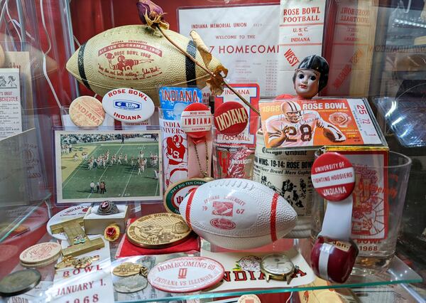 This 2022 image provided by Brett White shows a display of Indiana Hoosiers Rose Bowl sports memorabilia at White's home in Bloomington, Ind. White and other Indiana fans are riding the euphoria of a great season that culminated in a berth in the College Football Playoff. The Hoosiers will meet Notre Dame on Friday night in South Bend, Ind. (Brett White via AP)