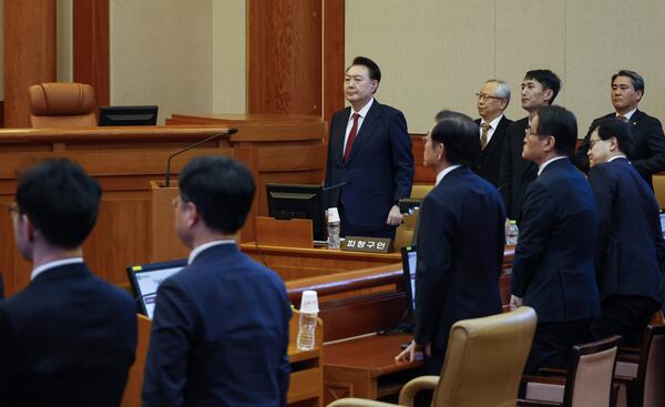 South Korea's impeached President Yoon Suk Yeol, center, stands as he attends the fourth hearing of his impeachment trial over his short-lived imposition of martial law at the Constitutional Court in Seoul, South Korea, Jan.23, 2025. (Jeon Heon Kyun/Pool Photo via AP)