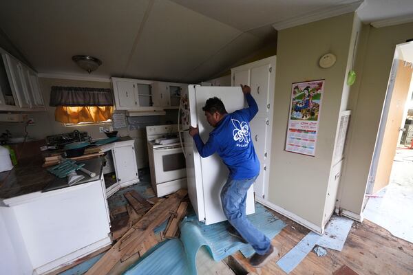 Mario Mendoza works on repairing a mobile home in Belle Chasse, La., Wednesday, Jan. 15, 2025, that was damaged from Hurricane Ida in 2021. (AP Photo/Gerald Herbert)