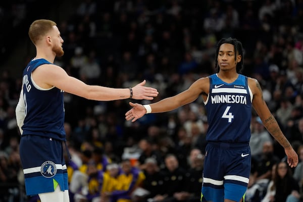 Minnesota Timberwolves guards Donte DiVincenzo (0) and Rob Dillingham (4) react during the first half of an NBA basketball game against the Los Angeles Lakers, Friday, Dec. 13, 2024, in Minneapolis. (AP Photo/Abbie Parr)