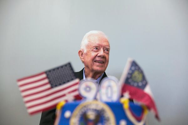 FILE - Former President Jimmy Carter stands behind his birthday cake during his 90th birthday celebration held at Georgia Southwestern University, Oct. 4, 2014, in Americus, Ga. (AP Photo/Branden Camp, File)