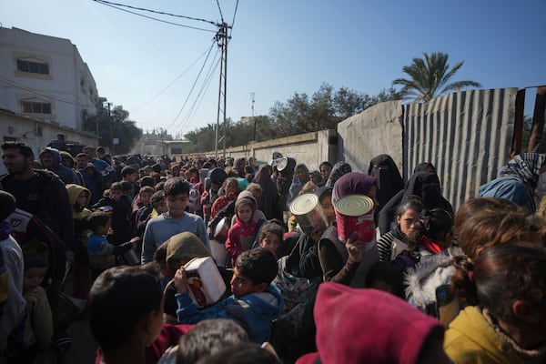 Palestinians queue for food in Deir al-Balah, Gaza Strip, Tuesday, Jan. 7, 2025. (AP Photo/Abdel Kareem Hana)