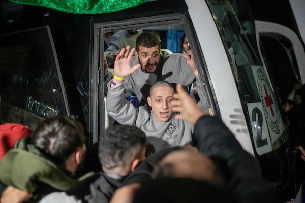 A Palestinian prisoner is greeted as he disembarks from a bus after being released from an Israeli prison, in the West Bank city of Beitunia, early Monday, Jan. 20, 2025. (AP Photo/Leo Correa)