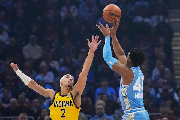 Cleveland Cavaliers guard Donovan Mitchell (45) shoots over Indiana Pacers guard Andrew Nembhard (2) in the first half of an NBA basketball game, Sunday, Jan. 12, 2025, in Cleveland. (AP Photo/Sue Ogrocki)