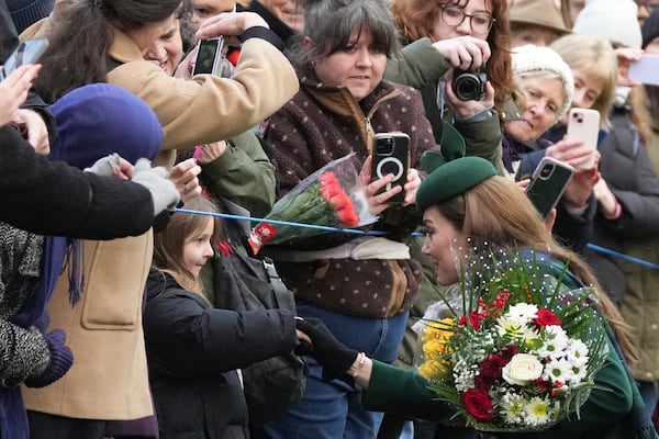 Kate, Princess of Wales shakes hands with a little girl as she greet members of the public after attending the Christmas day service at St Mary Magdalene Church in Sandringham in Norfolk, England, Wednesday, Dec. 25, 2024. (AP Photo/Jon Super)