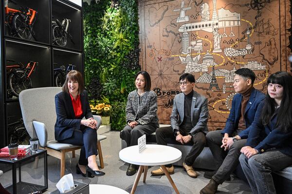 Britain's Chancellor of the Exchequer Rachel Reeves, 1st left, talks with the employees of Brompton flagship store in Beijing, Saturday, Jan. 11, 2025. (Jade Gao/Pool Photo via AP)