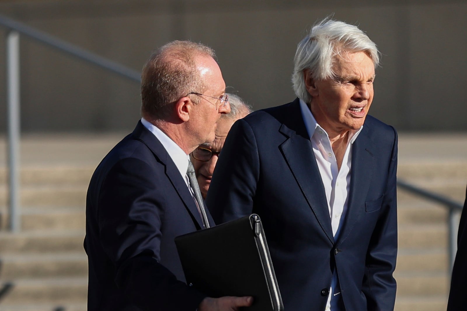 Michael Jeffries, former CEO of Abercrombie & Fitch, right, exits the federal courthouse after his arraignment on sex trafficking and interstate prostitution charges, Friday, Oct. 25, 2024, in Central Islip, N.Y. (AP Photo/Heather Khalifa)