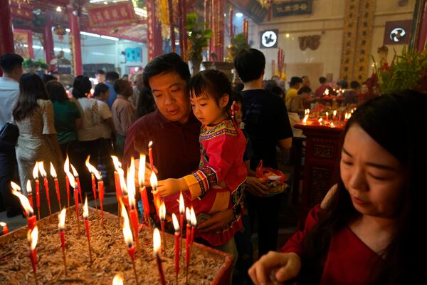 Chinese people offer candles and pray at a temple during their New Year day of the Snake at Chinatown in Yangon, Myanmar, Wednesday, Jan. 29, 2025. (AP Photo/Thein Zaw)