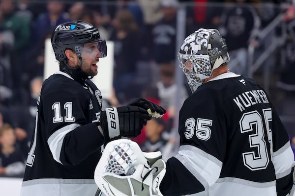 Los Angeles Kings center Anze Kopitar, left, celebrates with goaltender Darcy Kuemper after the team's win against the New Jersey Devils during an NHL hockey game, Wednesday, Jan. 1, 2025, in Los Angeles. (AP Photo/Ryan Sun)