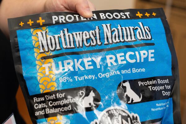 A pet store employee holds a bag of Northwest Naturals 2-pound Feline Turkey Recipe raw frozen pet food in Tigard, Ore., on Thursday, Dec. 26, 2024, after it was taken off the shelves as part of a voluntary recall by the manufacturer. (AP Photo/Jenny Kane)