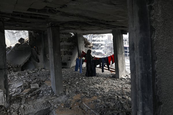 A Palestinian woman hangs the laundry inside her home, which was destroyed in the Israeli bombardment of the Gaza Strip, Tuesday, Jan. 28, 2025. (AP Photo/Jehad Alshrafi)