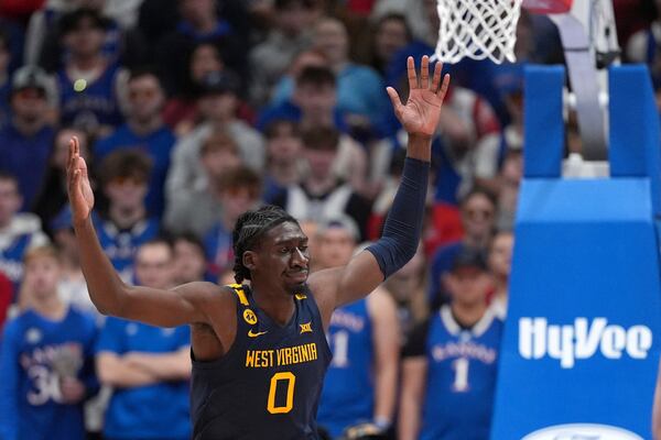 West Virginia center Eduardo Andre celebrates after dunking the ball during the first half of an NCAA college basketball game against Kansas, Tuesday, Dec. 31, 2024, in Lawrence, Kan. (AP Photo/Charlie Riedel)