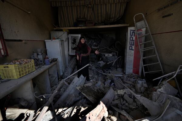 Mariam Kourani, 56, stands on her destroyed butcher shop after she returned with her family to Hanouiyeh village, southern Lebanon, Thursday, Nov. 28, 2024 following a ceasefire between Israel and Hezbollah that went into effect on Wednesday.(AP Photo/Hussein Malla)