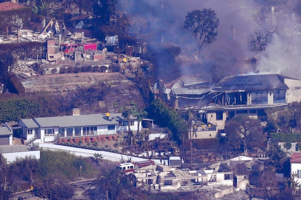 Firefighters protect what is left of homes from the Palisades Fire, Thursday, Jan. 9, 2025, in Malibu, Calif. (AP Photo/Mark J. Terrill)