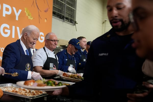 President Joe Biden, from left, and chef Robert Irvine serve food at a Friendsgiving event with service members and their families in the Staten Island borough of New York, Monday, Nov. 25 2024. (AP Photo/Manuel Balce Ceneta)