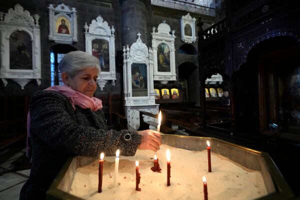 A Syrian woman lights a candle inside a church during the first Sunday Mass since Syrian President Bashar Assad's ouster, in old Damascus, Syria, Sunday, Dec. 15, 2024. (AP Photo/Hussein Malla)