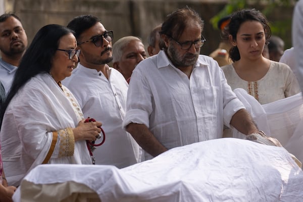 Indian actress Ila Arun, left, pay homage to Shyam Benegal, a renowned Indian filmmaker who passed away on Monday, during Benegal's funeral in Mumbai, India, Tuesday, Dec. 24, 2024. (AP Photo/Rafiq Maqbool)