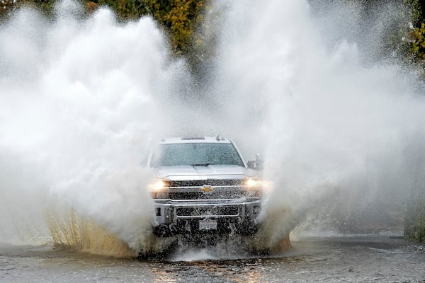 A pick-up truck drives through floodwaters as heavy rains fall in Windsor, Calif., on Friday, Nov. 22, 2024. (AP Photo/Noah Berger)