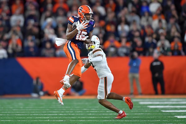 Syracuse wide receiver Justus Ross-Simmons, left, catches a pass over Miami defensive back Daryl Porter Jr. (2) during the first half of an NCAA football game on Saturday, Nov. 30, 2024 in Syracuse, N.Y. (AP Photo/Adrian Kraus)