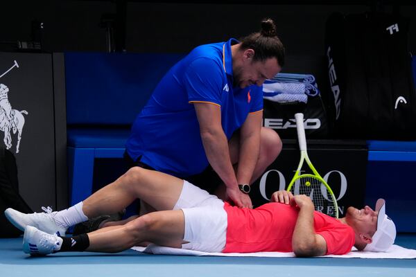 Alejandro Davidovich Fokina of Spain receives treatment during a fourth round match against Tommy Paul of the U.S. at the Australian Open tennis championship in Melbourne, Australia, Sunday, Jan. 19, 2025. (AP Photo/Vincent Thian)