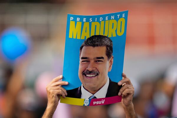 FILE - A supporter displays a poster of President Nicolas Maduro during his closing election campaign rally in Caracas, Venezuela, July 25, 2024. (AP Photo/Fernando Vergara, File)