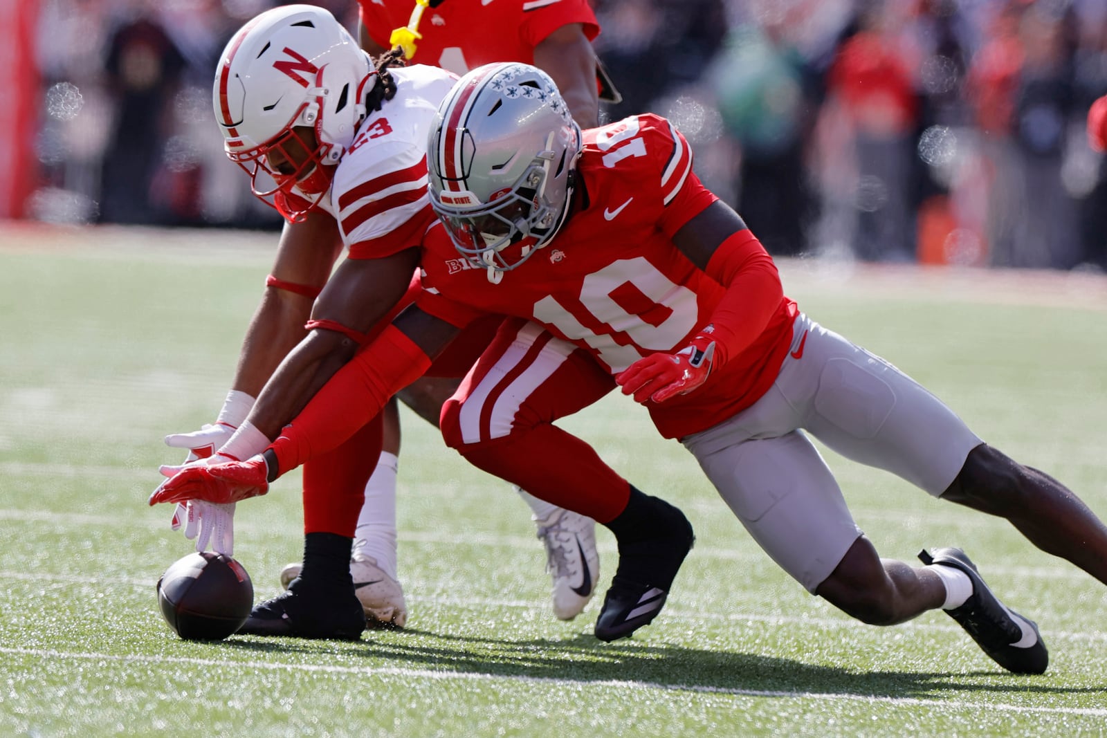 Nebraska running back Dante Dowdell, left, and Ohio State defensive back Denzel Burke chase a fumbled ball during the first half of an NCAA college football game Saturday, Oct. 26, 2024, in Columbus, Ohio. (AP Photo/Jay LaPrete)