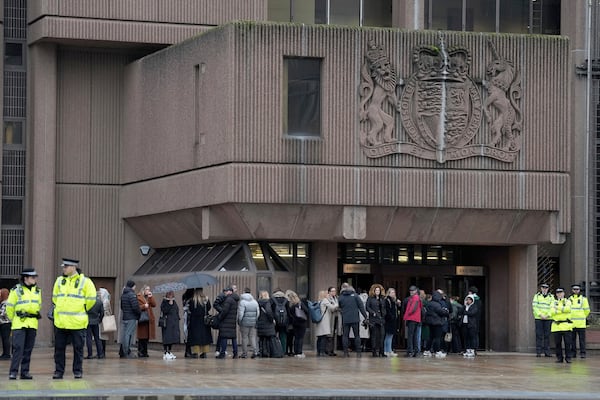 People queue at Liverpool Crown Court in Liverpool, England, Monday, Jan. 20, 2025 where Axel Rudakubana is charged with killing three girls and wounding 10 other people in a stabbing rampage at a Taylor Swift-themed dance class in England last summer.(AP Photo/Jon Super)