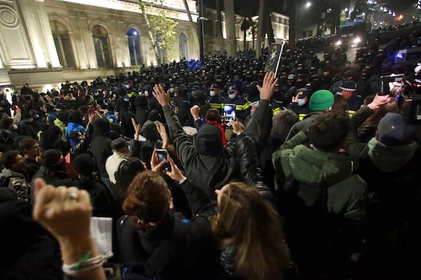 Demonstrators stand in front of police during a rally outside the parliament's building to protest the government's decision to suspend negotiations on joining the European Union for four years in Tbilisi, Georgia, on Saturday, Nov. 30, 2024. (AP Photo/Zurab Tsertsvadze)