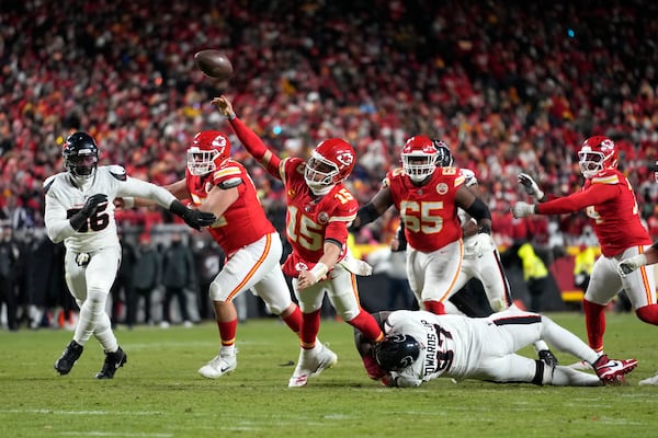 Kansas City Chiefs quarterback Patrick Mahomes (15) throws a touchdown pass to tight end Travis Kelce under pressure from Houston Texans defensive tackle Mario Edwards Jr. (97) during the second half of an NFL football AFC divisional playoff game Saturday, Jan. 18, 2025, in Kansas City, Mo. (AP Photo/Ed Zurga)