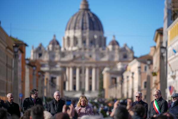 Italian Premier Giorgia Meloni, center, backdropped by St.Peter's Basilica, delivers her speech in Rome, Italy, Monday, Dec. 23, 2024 during the opening ceremony of a new pedestrian area in the nearby of the Vatican, just ahead of the Jubilee Year, an event expected to draw millions of visitors to the Eternal City. (AP Photo/Andrew Medichini)