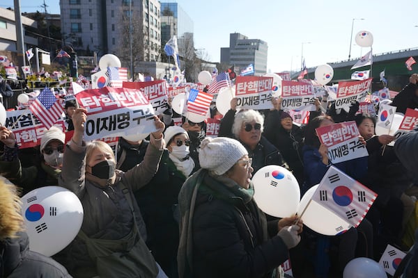 Supporters of impeached South Korean President Yoon Suk Yeol stage a rally near the presidential residence in Seoul, South Korea, Tuesday, Dec. 31, 2024. The letters read "Oppose Impeachment," and "Arrest Lee Jae-myung." (AP Photo/Lee Jin-man)