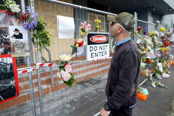 A man reads messages left on the fence outside the fire damaged Adass Israel Synagogue in Melbourne, Monday, Dec. 9, 2024. (Con Chronis/AAP Image via AP)