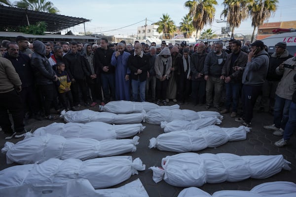 Mourners pray next to the bodies of Palestinians who were killed in the Israeli bombardment of the Gaza Strip at Al-Aqsa Hospital in Deir al-Balah, Wednesday, Jan. 15, 2025. (AP Photo/Abdel Kareem Hana)