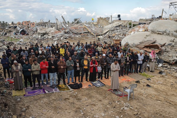 Palestinians perform Friday prayers near the ruins of a mosque destroyed by the Israeli airstrikes in Khan Younis, Gaza Strip, Friday, Jan. 24, 2025, days after the ceasefire deal between Israel and Hamas came into effect. (AP Photo/Jehad Alshrafi)