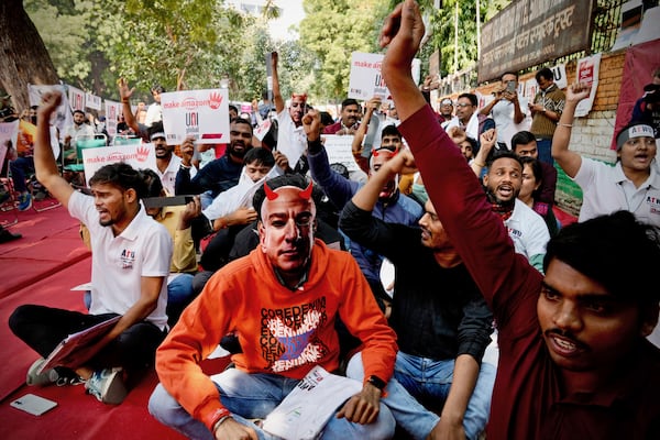 A participant wears a paper mask in the likeness of Amazon's Jeff Bezos as warehouse workers and delivery drivers stage a protest against the Seattle-based company demanding higher wages and better working conditions, in New Delhi, India, Friday, Nov. 29, 2024. (AP Photo/Manish Swarup)