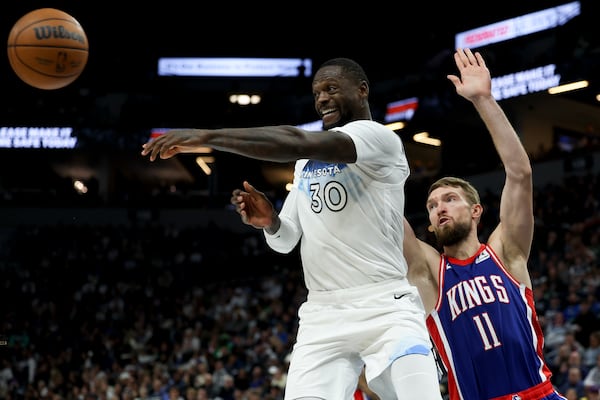 Minnesota Timberwolves forward Julius Randle (30) passes the ball while Sacramento Kings forward Domantas Sabonis (11) defends during the second half of an NBA basketball game, Wednesday, Nov. 27, 2024, in Minneapolis. (AP Photo/Ellen Schmidt)