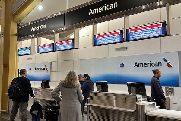 Signs display an "Emergency Alert" above an American Airlines counter in the terminal at Ronald Reagan Washington National Airport, Wednesday night, Jan. 29, 2025, in Arlington, Va. A jet with 60 passengers and four crew members aboard collided with an Army helicopter while landing at Ronald Reagan National Airport near Washington, prompting a large search-and-rescue operation in the nearby Potomac River. (AP Photo/Jeannie Ohm)