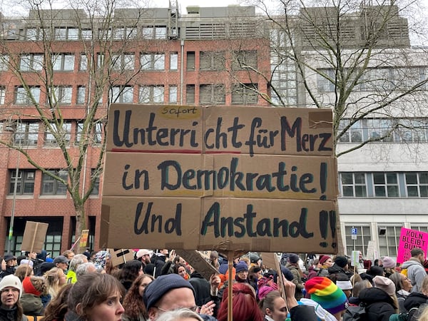 People gather to protest against the Far Right, in Cologne, Germany, Saturday Jan. 25, 2025. Banner reads: "Immediate lessons for Merz in democracy and decency". (Christoph Driessen/dpa via AP)