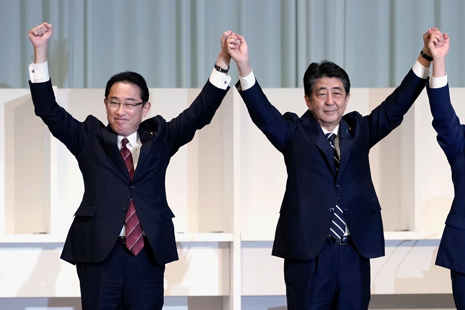 FILE - Former Japan's Foreign Minister Fumio Kishida, left, and Prime Minister Shinzo Abe celebrate after Chief Cabinet Secretary Yoshihide Suga was elected as new head of Japan's ruling party at the Liberal Democratic Party's (LDP) leadership election in Tokyo on Sept. 14, 2020. (AP Photo/Eugene Hoshiko, Pool, File)