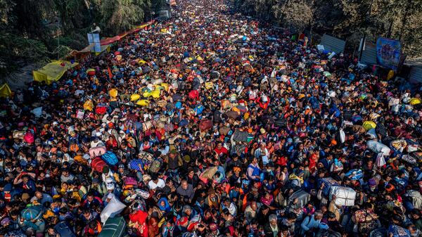 Indian Hindu devotees arrive for a holy dip at Sangam, the confluence of the Ganges, the Yamuna and the mythical Saraswati rivers, on the eve of the 'Mauni Amavasya' or new moon day during the Mahakumbh festival, in Prayagraj, Uttar Pradesh, India, Tuesday, Jan. 28, 2025. (AP Photo/Rajesh Kumar Singh)