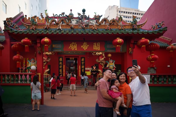 A Malaysian ethnic Chinese family takes picture on the first day of Lunar New Year at Guandi Temple, in Kuala Lumpur, Malaysia, Wednesday, Jan. 29, 2025. (AP Photo/Vincent Thian)