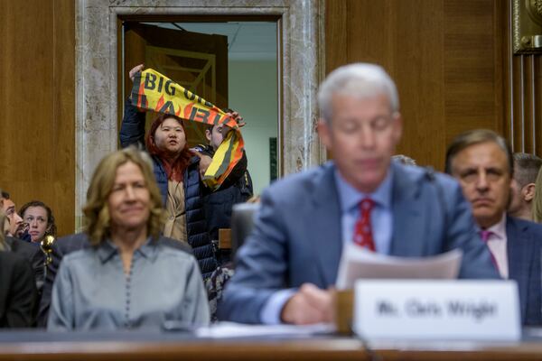 A protestor interrupts Chris Wright, President-elect Donald Trump's nominee to be Secretary of Energy as he reads his opening statement during a Senate Committee on Energy and Natural Resources hearing for his pending confirmation, on Capitol Hill, Wednesday, Jan. 15, 2025, in Washington. (AP Photo/Rod Lamkey, Jr.)