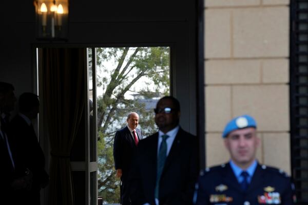 A United Nations peacekeeper stands guards as leader of the breakaway Turkish Cypriots Ersin Tatar stands in the background, while waiting for Cypriot President Nikos Christodoulides to arrive for a meeting with Chief of Mission in Cyprus Colin Stewart, at the U.N. official's residence inside a U.N.-controlled buffer zone cutting across the divided capital Nicosia, Cyprus, Monday, Jan. 20, 2025. (AP Photo/Petros Karadjias)