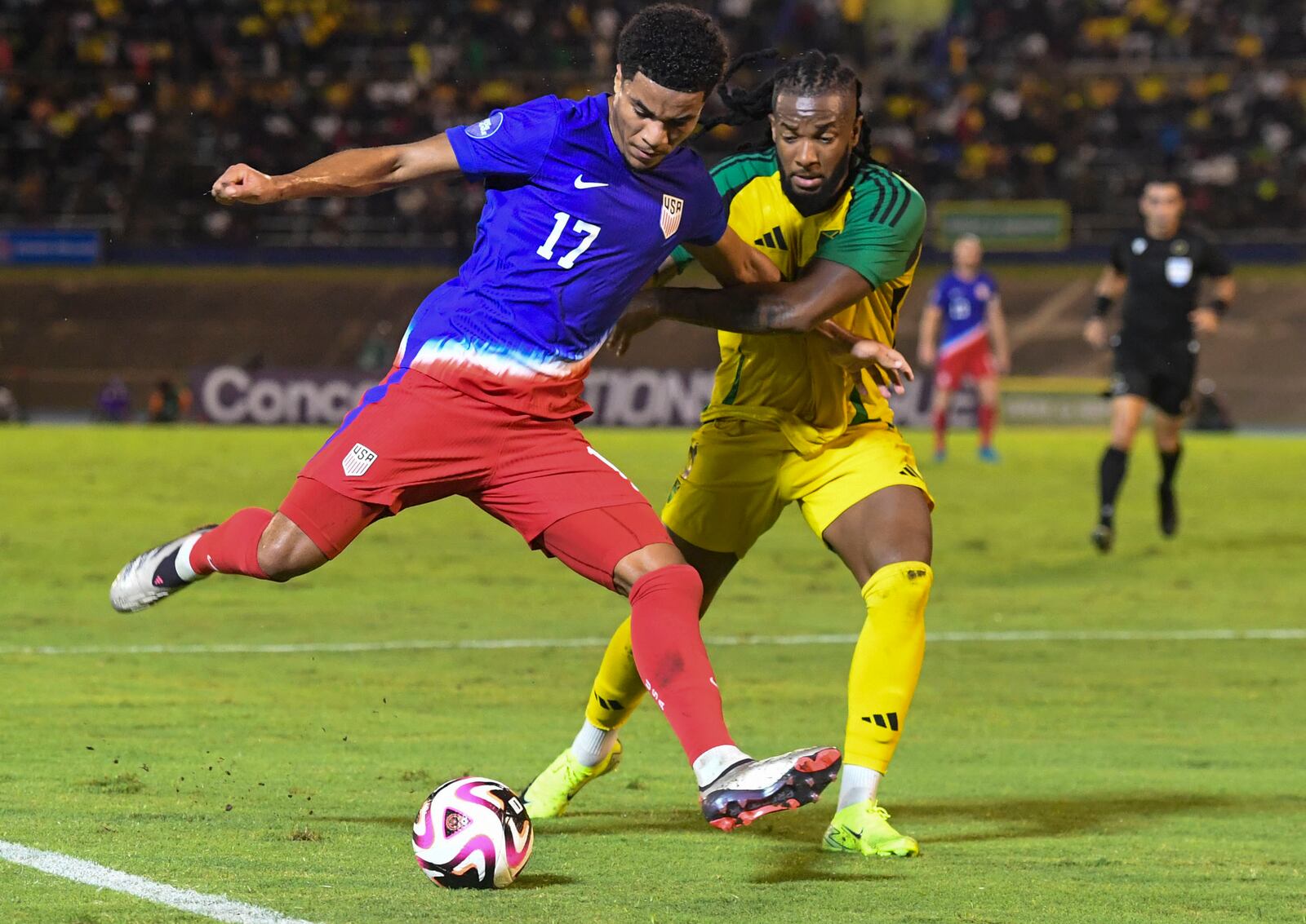 United States' Malik Tillman, left, fights for the ball against Jamaica's Kasey Palmer during a CONCACAF Nations League quarterfinal first leg soccer match in Kingston, Jamaica, Thursday, Nov. 14, 2024. (AP Photo/Collin Reid)