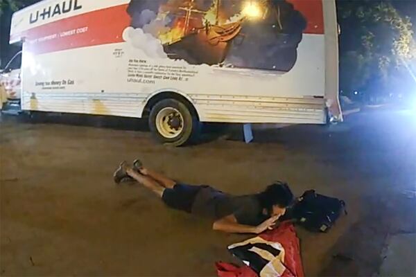 In this body camera image from video provided by the Justice Department in the government's sentencing memo, Sai Varshith Kandula is seen with a Nazi Flag once he was ordered down by the United States Park Police after nearly striking two people standing next to a park bench when he steered a U-Haul box truck onto a sidewalk and toward metal bollards that prevent vehicles from entering Lafayette Square, north of the White House, May 22, 2023, in Washington. (Justice Department via AP)